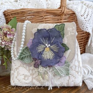 Made in the hoop silk pansy flower on elegant purse - Spring Blooms machine embroidery designs from A Bit of Stitch