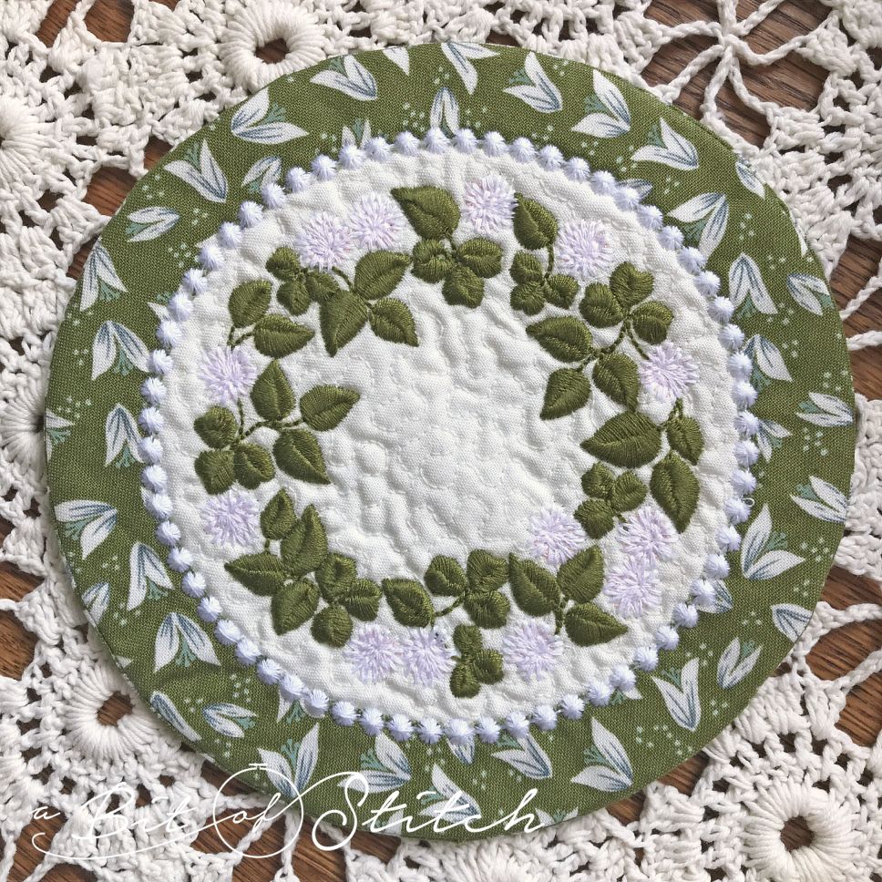"Rolling in Clover" machine embroidery designs by A Bit of Stitch. Clover flower vine wreath design on MITH circle coaster