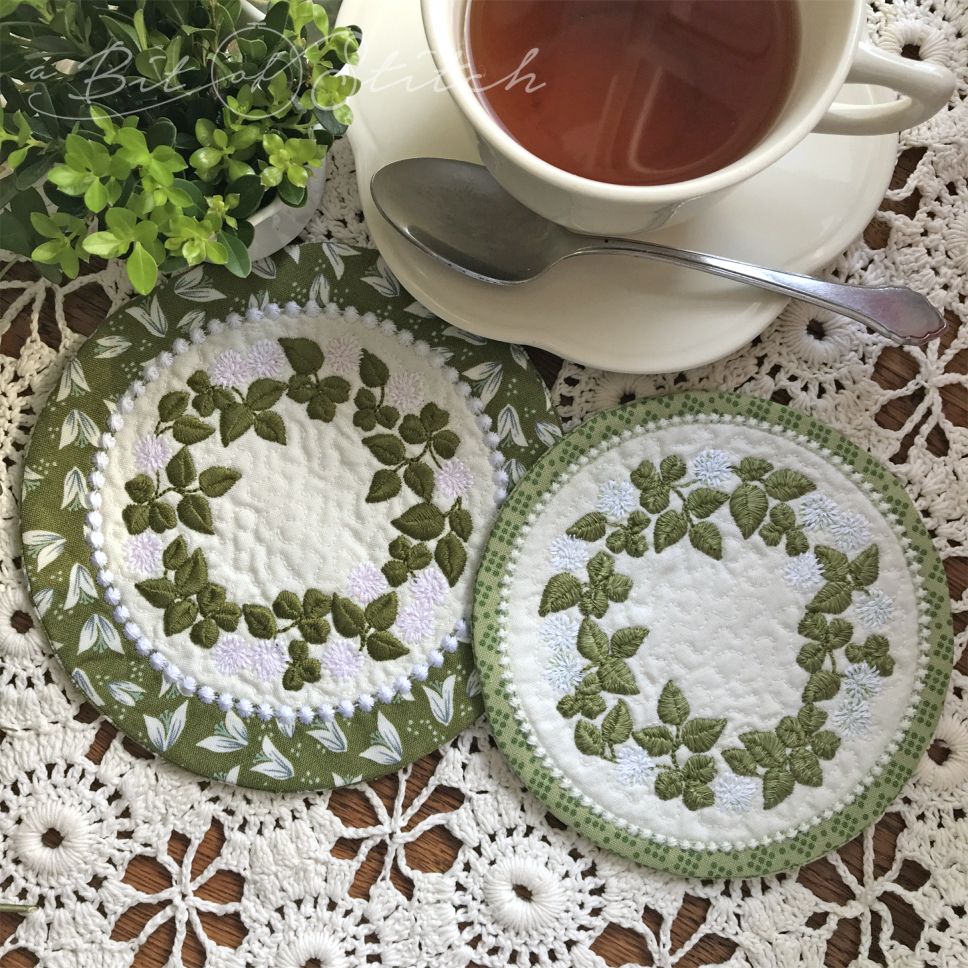 "Rolling in Clover" machine embroidery designs by A Bit of Stitch. Clover flower vine wreath designs on MITH circle coasters