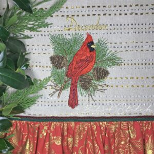 Realistic cardinal with pinecones and pine needles on tea towel - machine embroidery design by A Bit of Stitch