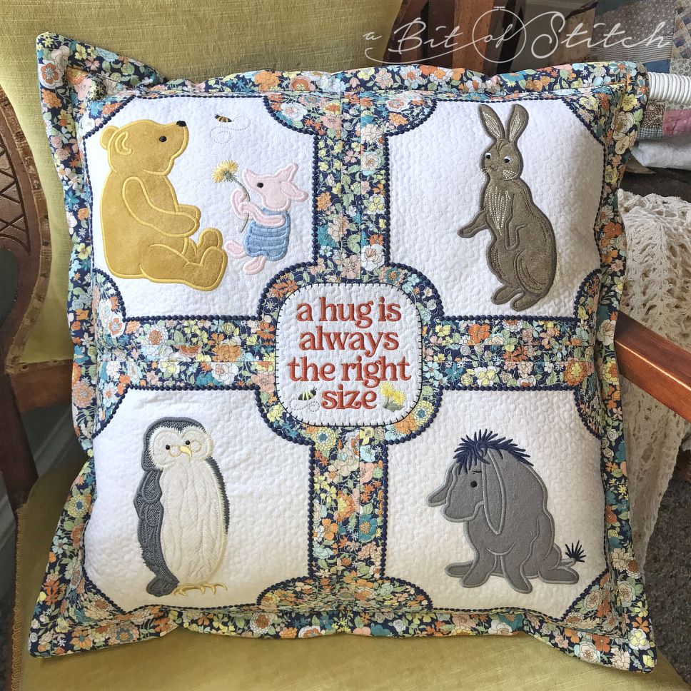 Winnie the Pooh, Piglet, Rabbit, Owl and Eeyore machine embroidery applique designs by A Bit of Stitch on pillow with lettering "A hug is always the right size."