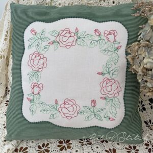 Throw pillow with embroidered square shaped wreath of delicate roses - machine embroidery design from A Bit of Stitch