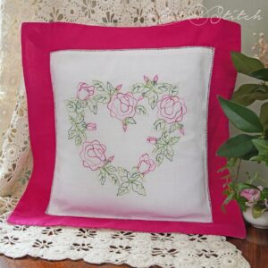 Throw pillow with delicate heart shaped rose wreath machine embroidery design from A Bit of Stitch