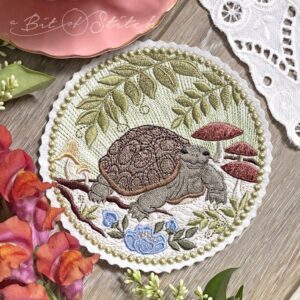 Realistic turtle embroidery framed by woodland floral background with ferns and mushrooms - machine embroidery design from A Bit of Stitch
